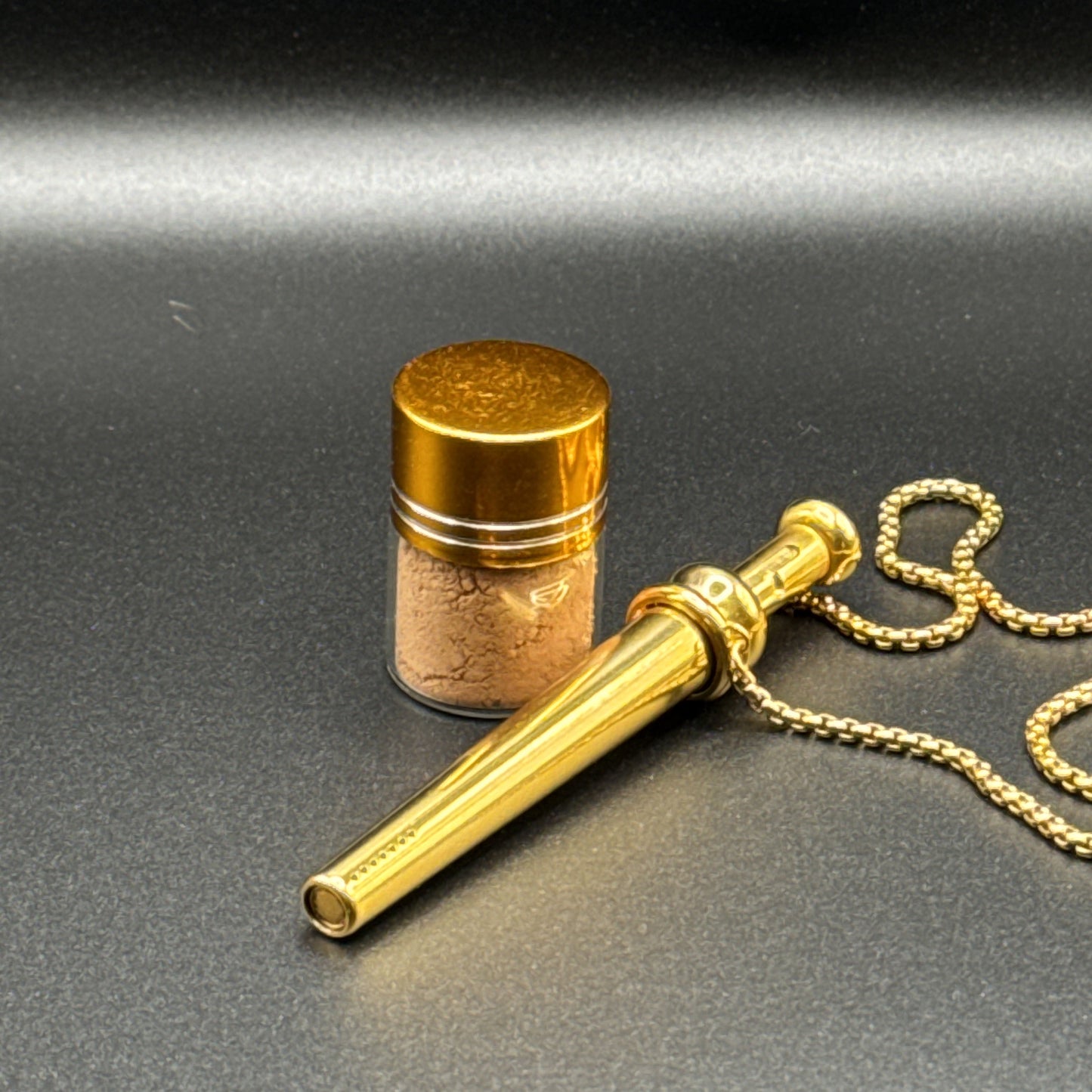 Gold necklaces with BumpHit pendants on a dark background